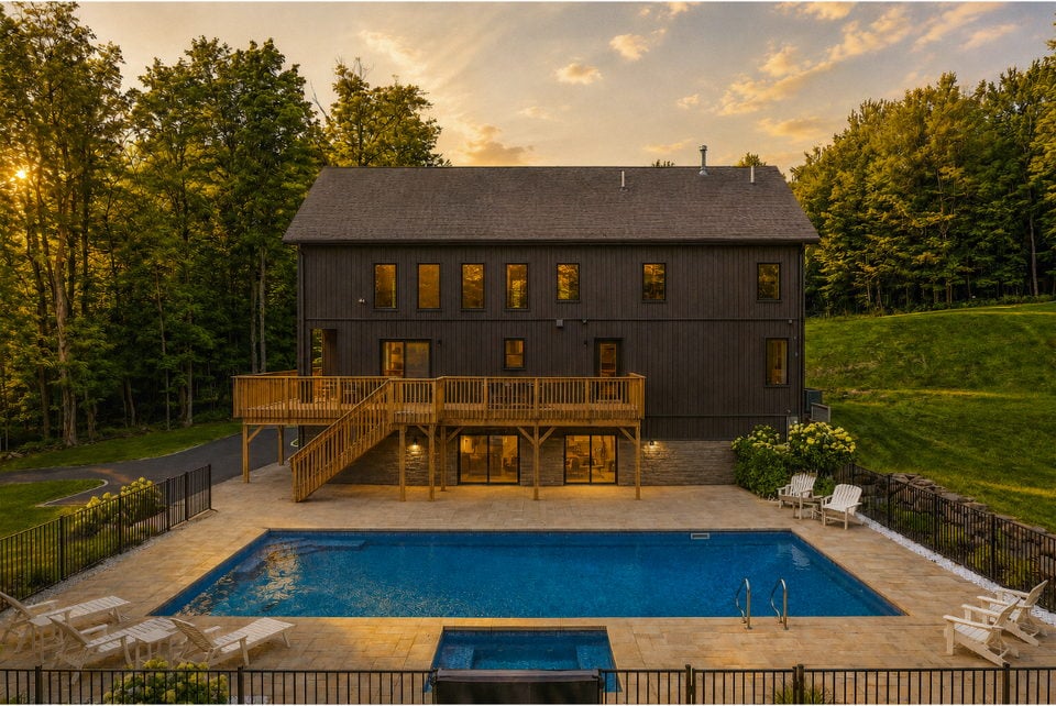 A Rustic Pines chalet at dusk with a heated pool at the edge of the forest